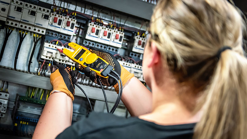 Drifttekniker (tjej) mäter el. Foto: Peter Malmrup