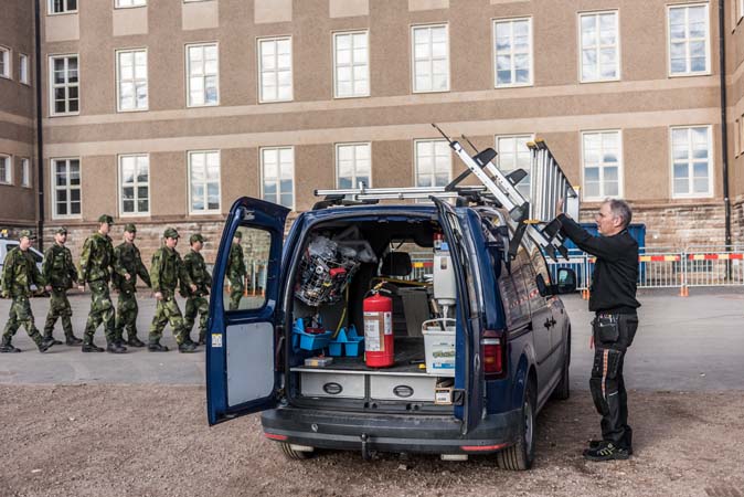 Fortverkare och militär pratar i ett stridsvagnsgarage