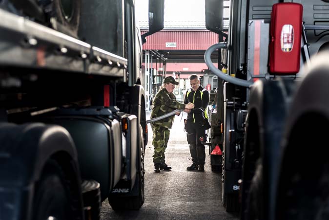 Miltär och Fortverkare mellan två lastbilar