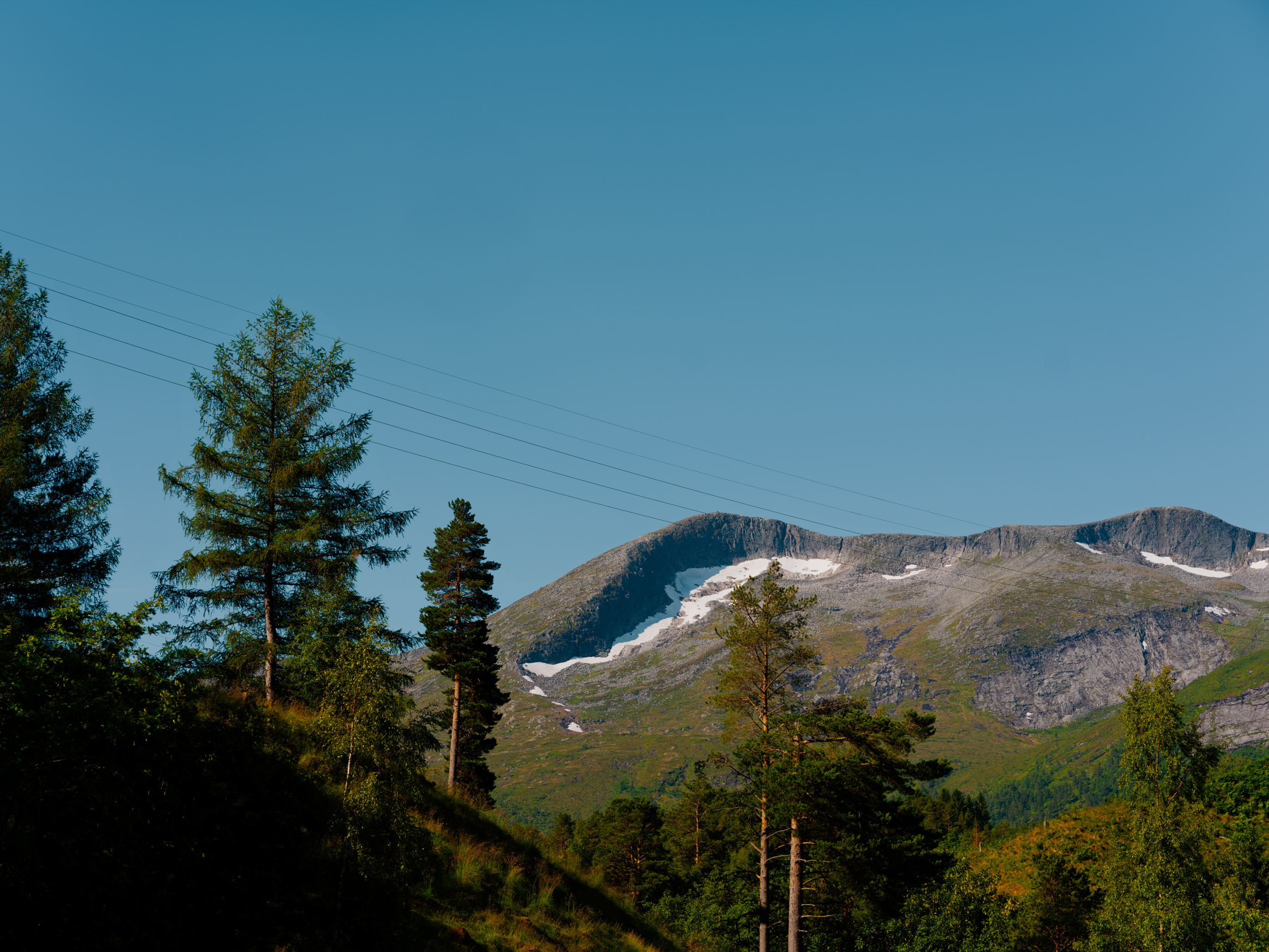 Fjell, blå himmel og strømlinje