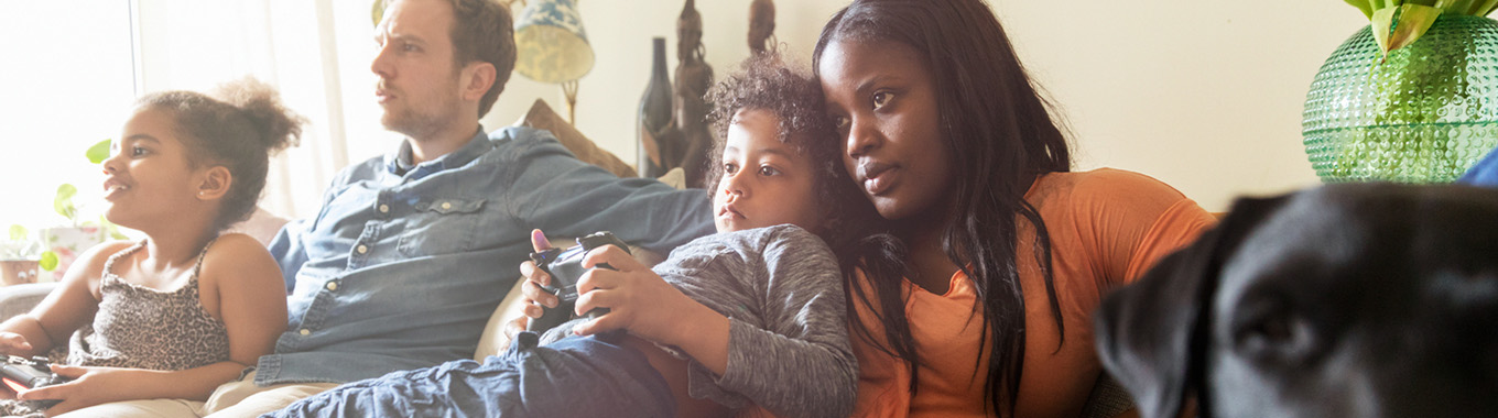 En familj sitter tillsammans i en soffa.